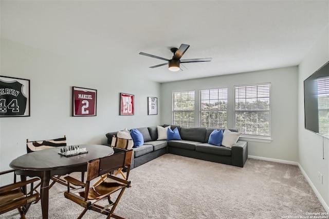 carpeted living room featuring ceiling fan and baseboards