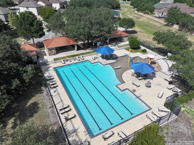 community pool featuring fence, a patio, and a gazebo