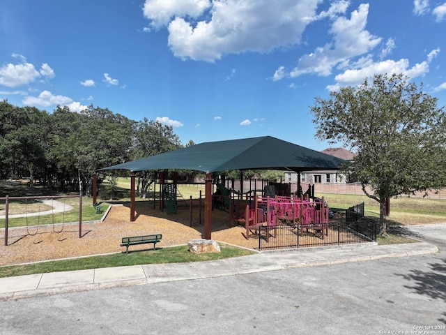 view of property's community featuring playground community and fence