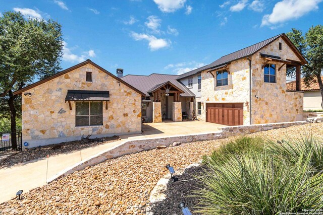 2204 Sierra Madre, Canyon Lake, TX 78133 - view of front of property featuring a garage, metal roof, stone siding, and a standing seam roof