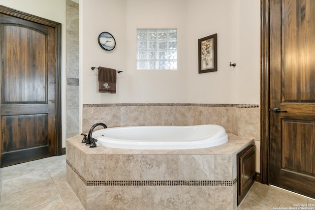 bathroom with tile patterned flooring and a relaxing tiled tub