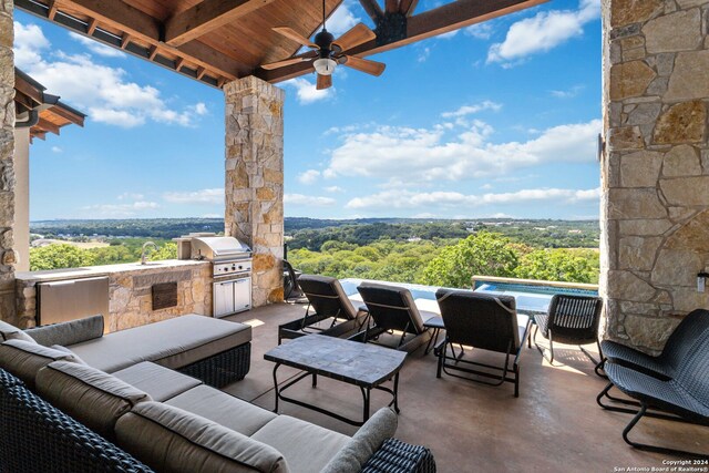 view of patio / terrace featuring ceiling fan, area for grilling, an outdoor living space, and an outdoor kitchen