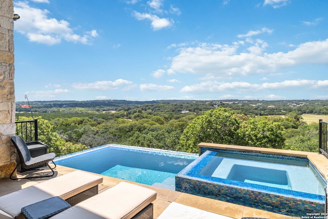 view of pool with an in ground hot tub