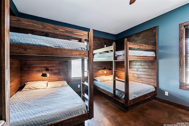 bedroom featuring wood walls and ceiling fan