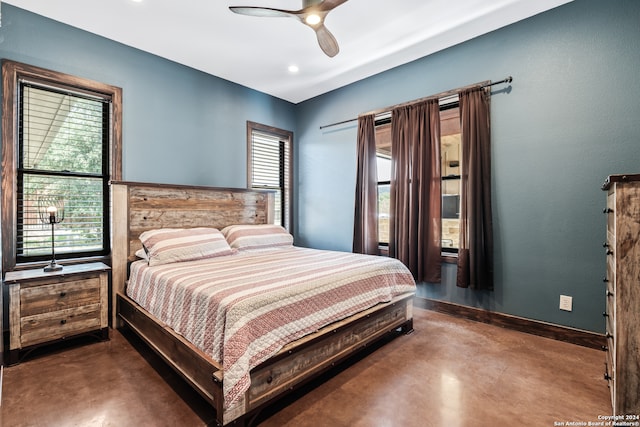 bedroom featuring multiple windows, concrete flooring, and ceiling fan