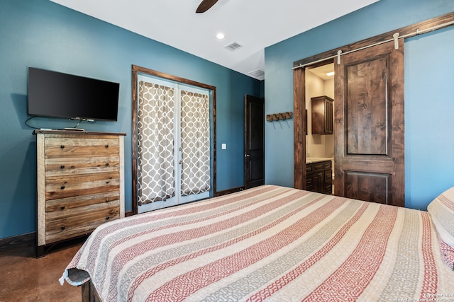 bedroom featuring carpet, ceiling fan, ensuite bath, and a barn door