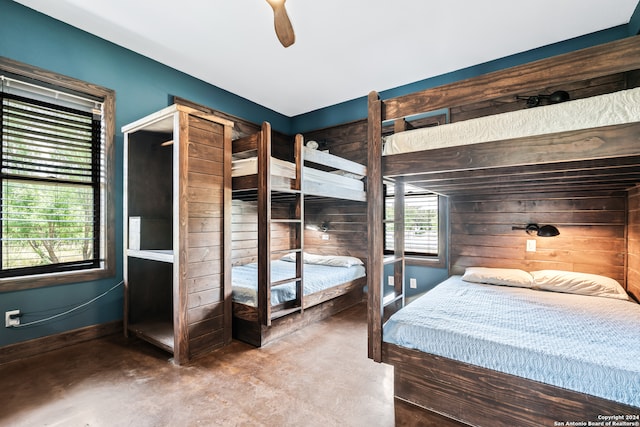 unfurnished bedroom with wood walls and ceiling fan