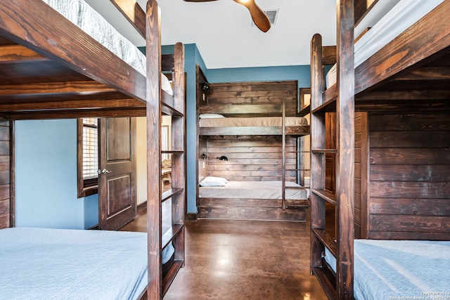 unfurnished bedroom with ceiling fan and wooden walls