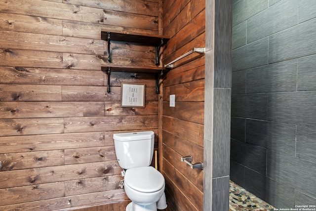 bathroom featuring wood walls and toilet