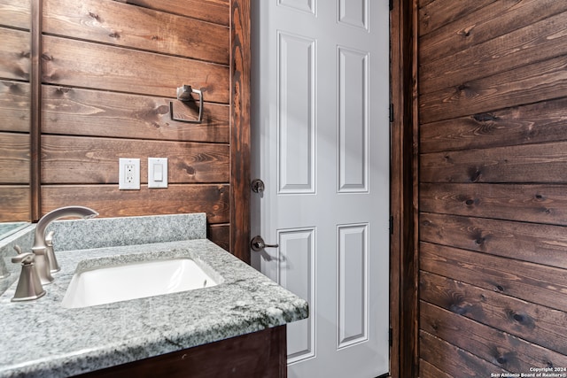 bathroom featuring wood walls and vanity