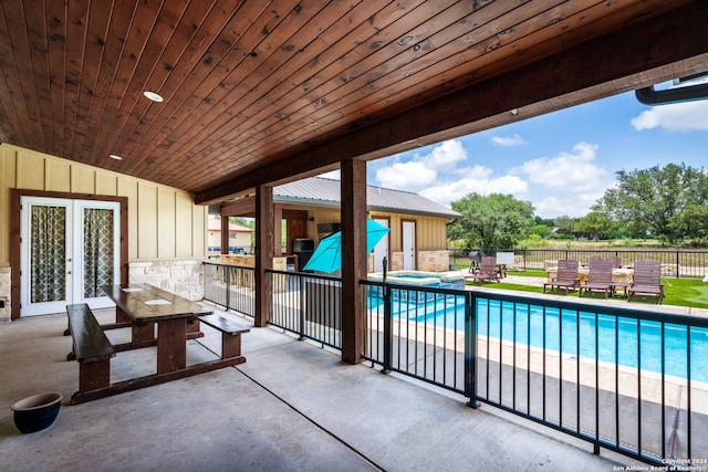 view of swimming pool featuring french doors and a patio area