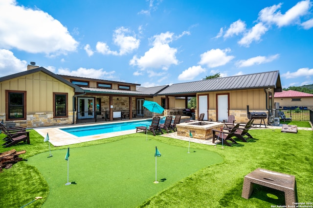 view of swimming pool with an outdoor fire pit, a patio area, and a yard