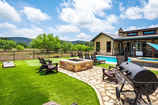 exterior space with a mountain view, a patio, a fenced in pool, and a fire pit