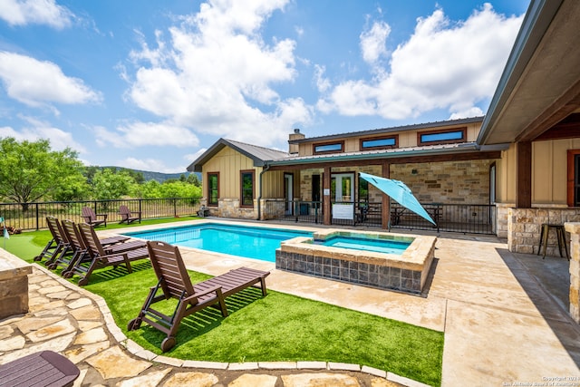 view of swimming pool with an in ground hot tub, a patio area, a bar, and a lawn