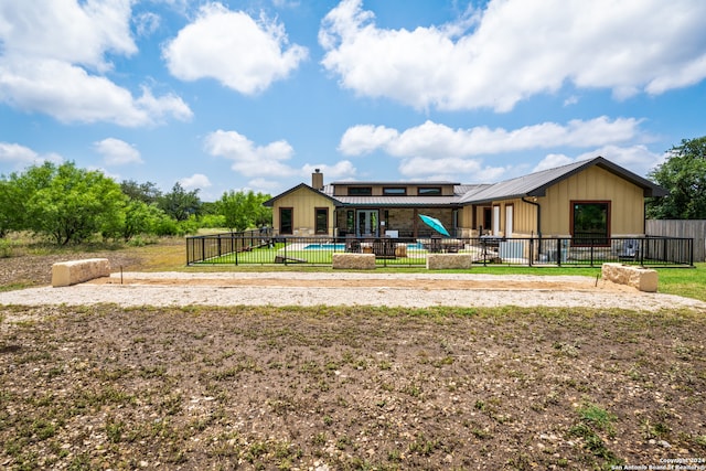 rear view of property with a swimming pool