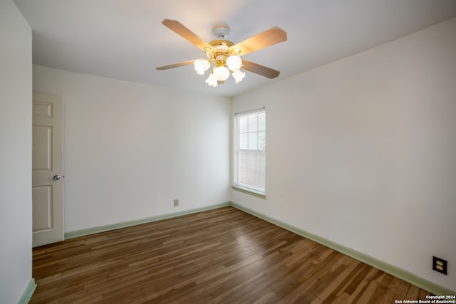 empty room featuring ceiling fan and dark wood-type flooring