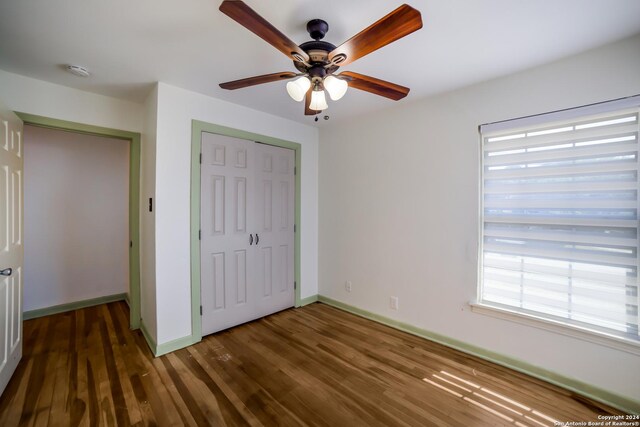 unfurnished bedroom featuring a closet, ceiling fan, and hardwood / wood-style flooring