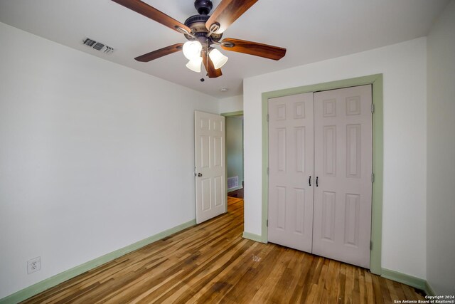 unfurnished bedroom with hardwood / wood-style flooring, a closet, and ceiling fan