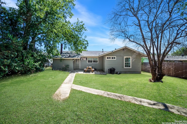 rear view of house with a lawn and a patio area