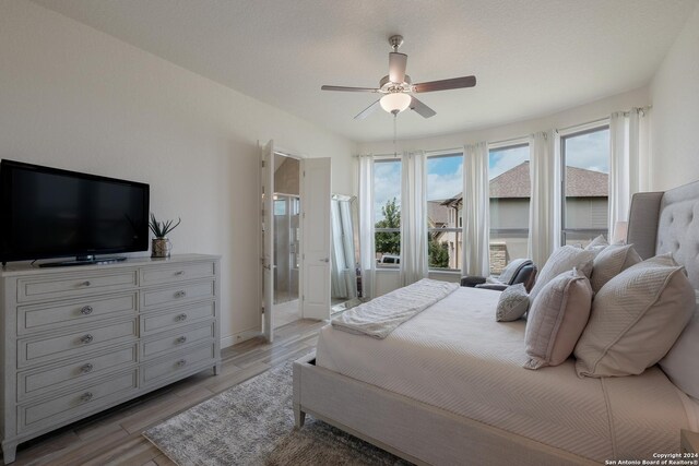 bedroom with hardwood / wood-style flooring, connected bathroom, and ceiling fan