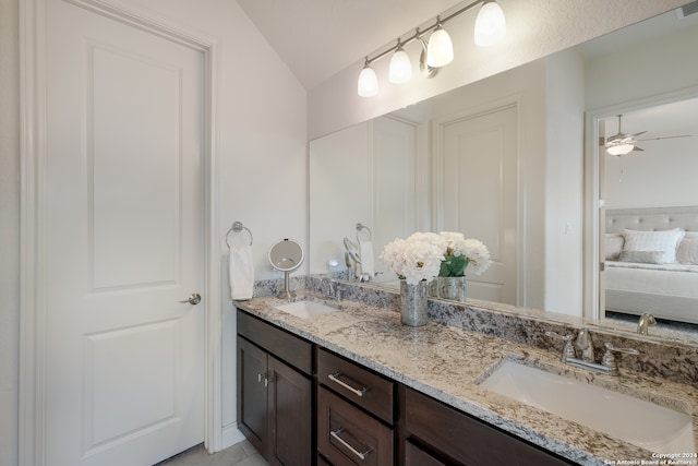 bathroom featuring ceiling fan, vaulted ceiling, and vanity