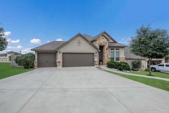 view of front of house featuring driveway, stone siding, an attached garage, a front lawn, and stucco siding