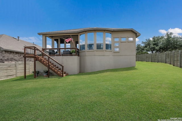 back of house featuring a deck and a yard