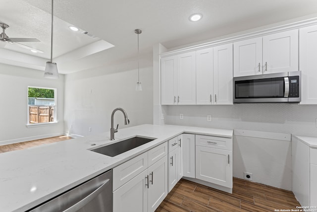 kitchen featuring ceiling fan, hanging light fixtures, white cabinetry, sink, and stainless steel appliances