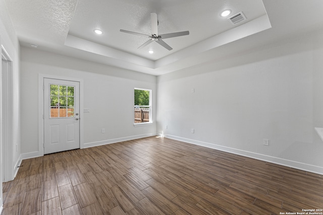 interior space with hardwood / wood-style floors, a raised ceiling, ceiling fan, and a textured ceiling