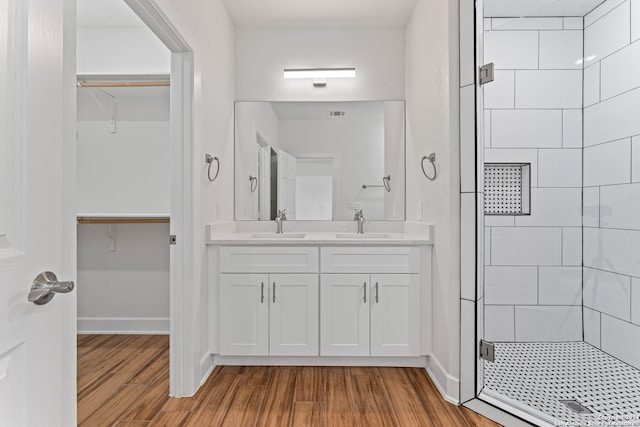 bathroom featuring wood-type flooring, a shower with door, and vanity