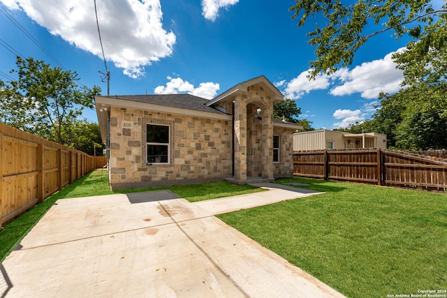 view of front of home with a front yard and a patio