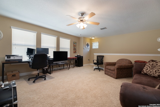 office space with ceiling fan, light colored carpet, and a textured ceiling