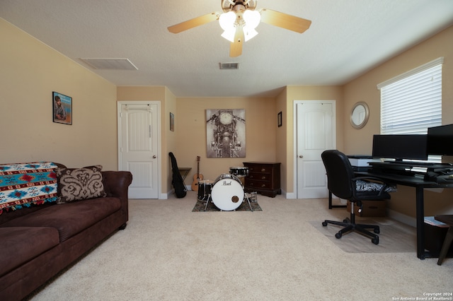 office area featuring a textured ceiling, ceiling fan, and light colored carpet