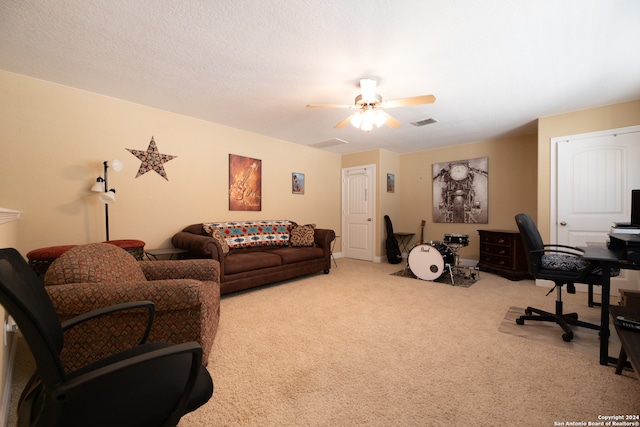 carpeted office space with ceiling fan and a textured ceiling