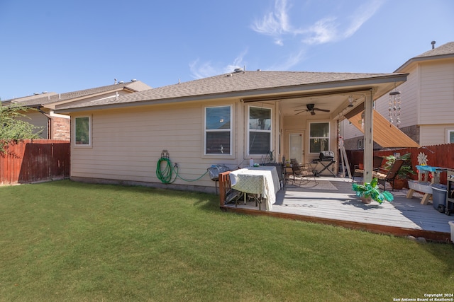 back of property featuring ceiling fan, a wooden deck, and a yard