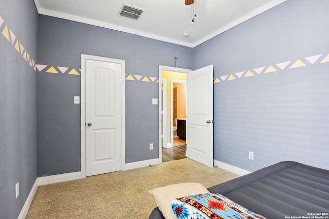 carpeted bedroom with ornamental molding and ceiling fan