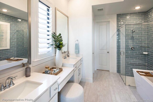 bathroom featuring independent shower and bath and vanity