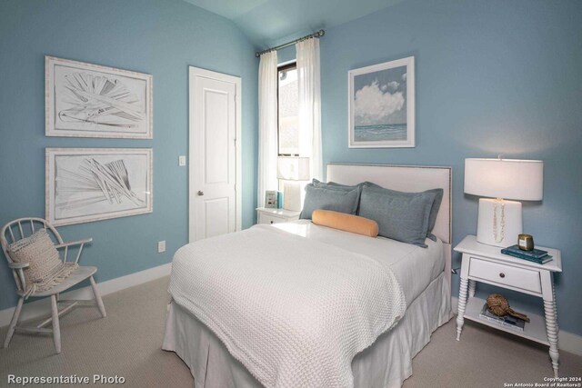 bedroom featuring carpet and vaulted ceiling