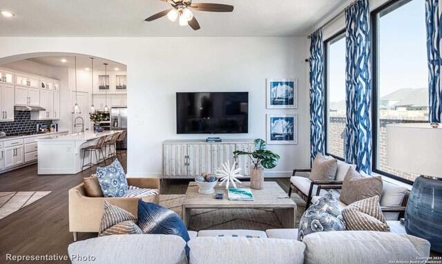 living room featuring ceiling fan, dark wood-type flooring, and sink