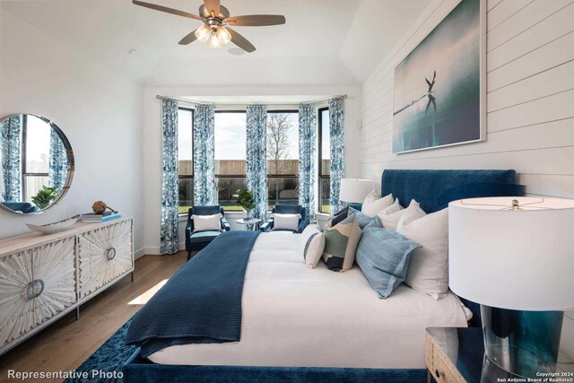 bedroom with ceiling fan, vaulted ceiling, and wood-type flooring