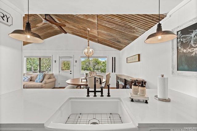 kitchen featuring lofted ceiling, wooden ceiling, a sink, hanging light fixtures, and light countertops