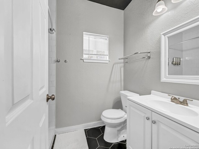 bathroom with toilet, vanity, and tile patterned floors