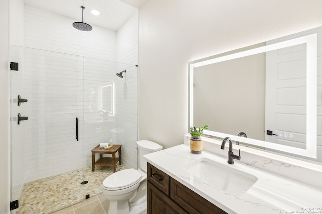 bathroom featuring toilet, a shower stall, tile patterned flooring, and vanity