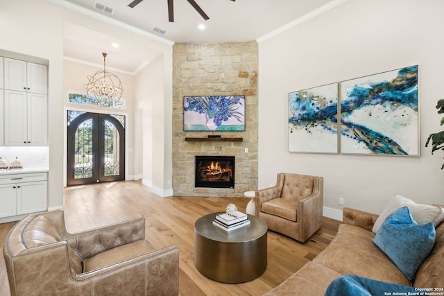 living area with light wood-type flooring, visible vents, and crown molding