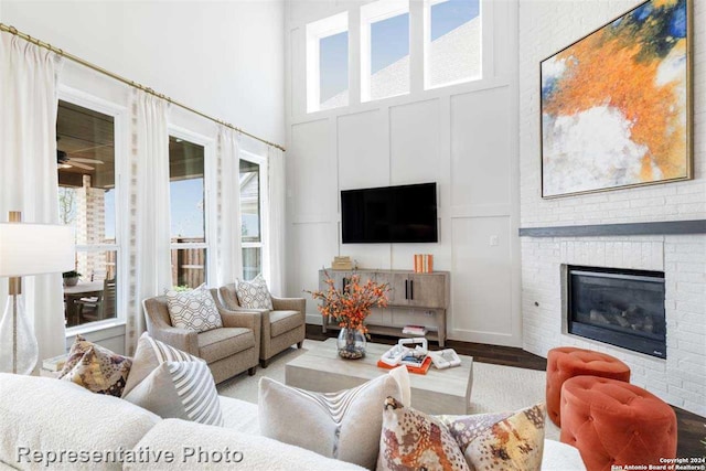 living room featuring hardwood / wood-style flooring, a high ceiling, and a fireplace