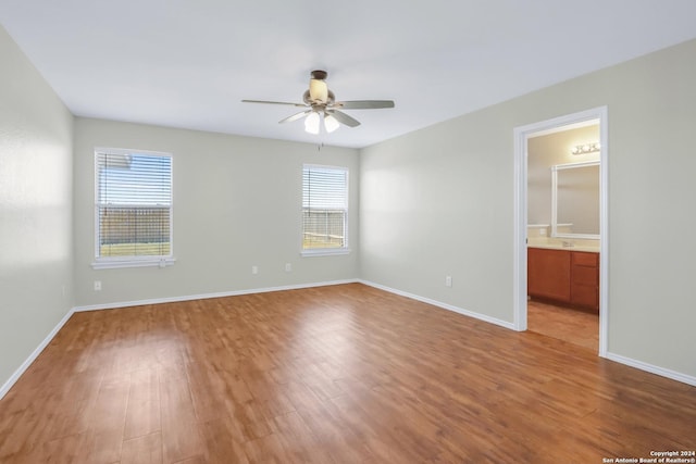 spare room with ceiling fan, plenty of natural light, and wood finished floors