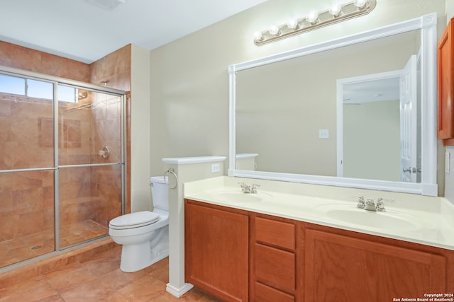 bathroom featuring a shower with door, toilet, tile patterned floors, and vanity