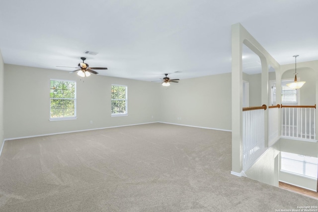 spare room with light colored carpet, visible vents, and baseboards