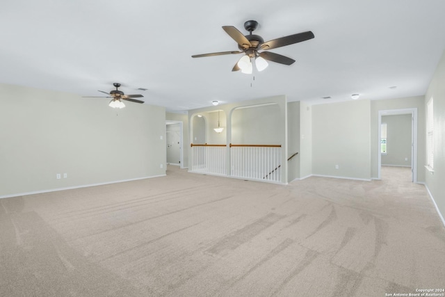 spare room featuring baseboards, a ceiling fan, and light colored carpet