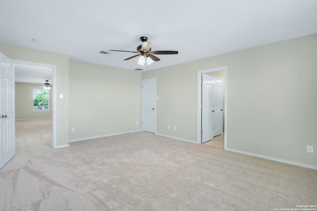 spare room featuring ceiling fan and light carpet